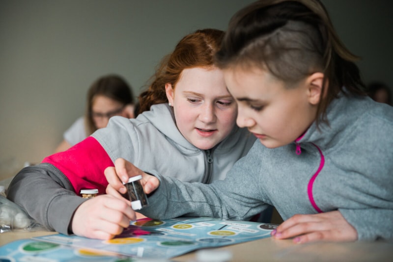 Two female students looking at seeds in class