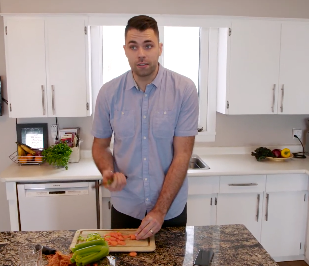 Farmer Will Bergmann chopping vegetables in kitchen