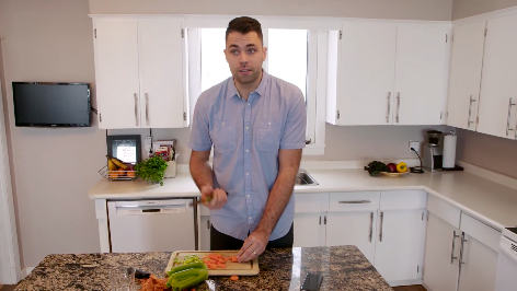 Farmer Will Bergmann chopping vegetables in kitchen
